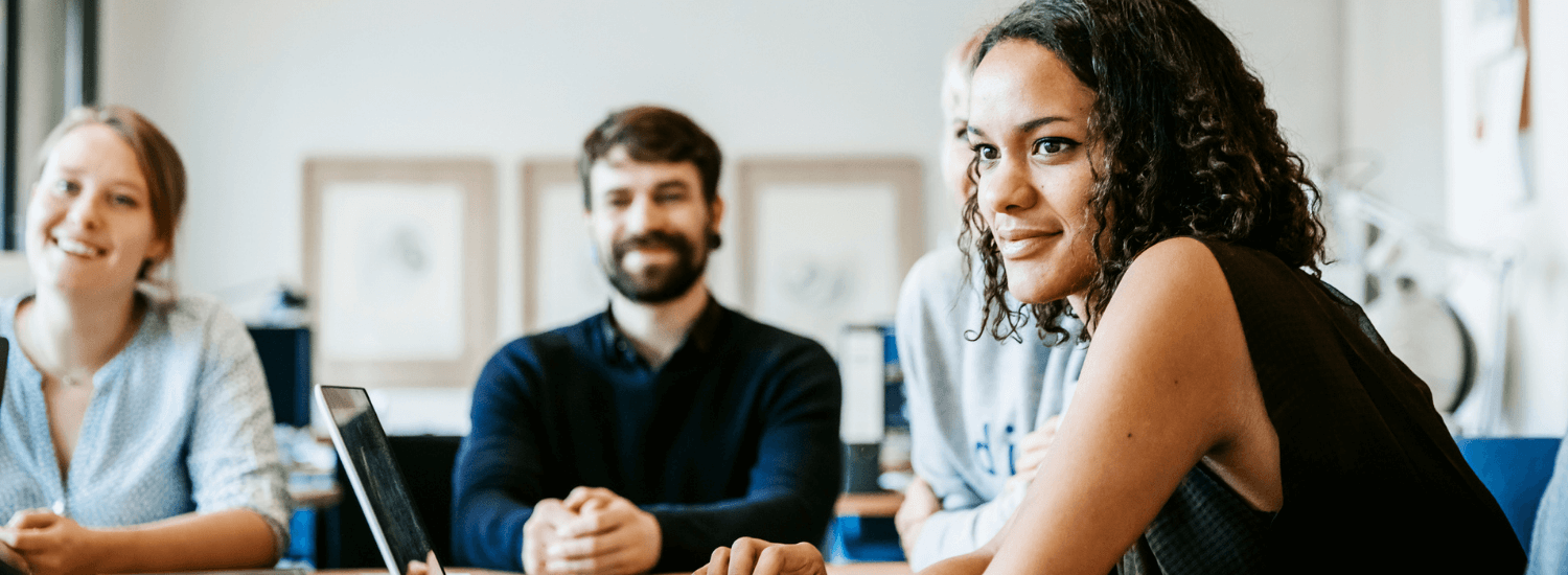 Group of business people smiling during a meeting.